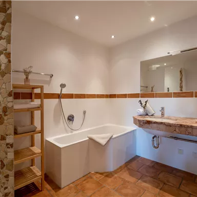 A modern bathroom with a bathtub and a wooden vanity. Bright walls and a pleasant atmosphere create relaxation.