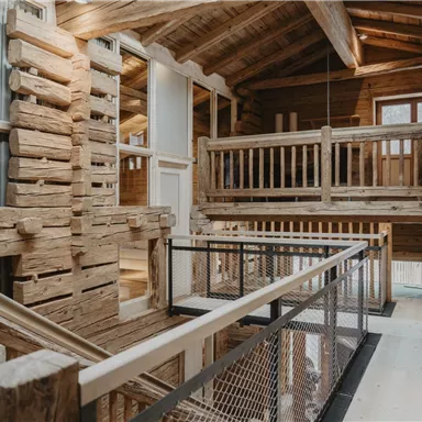 A modern wooden cabin with an open interior and many wooden details. The gallery and staircase create an inviting atmosphere.