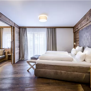 Ein modernes Hotelzimmer mit Holzverkleidung und zwei Einzelbetten. Große Fenster sorgen für viel Tageslicht und eine einladende Atmosphäre.