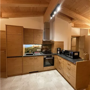 A modern kitchen with wooden cabinets and a black countertop. The atmosphere is bright and inviting.