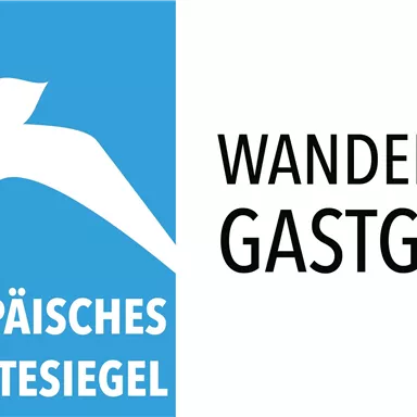 Ein Logo mit einem stilisierten Vogel und dem Text "Europäisches Wandergütesiegel". Daneben steht "Wanderaffiner Gastgeber".