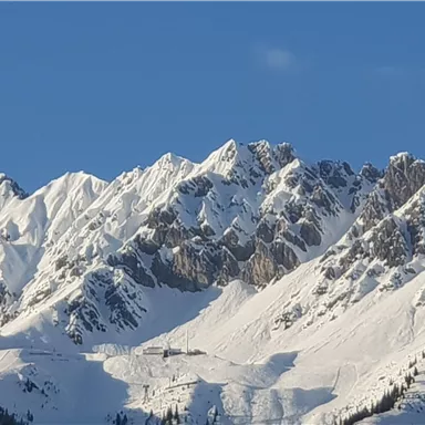 Schneebedeckte Berge unter einem klaren blauen Himmel. Eine beeindruckende Winterlandschaft.