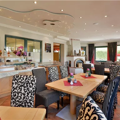 A cozy dining room with elegant furniture and beautiful table decorations. Large windows let in plenty of light and create an inviting atmosphere.
