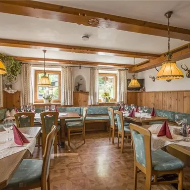 A cozy restaurant with wooden decor and beautiful tables. The atmosphere is inviting and traditional, with warm lighting and decorative elements.