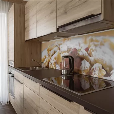 A modern kitchen with wooden shelves and a cooking field. In the background, there is an image of a delicious dish.