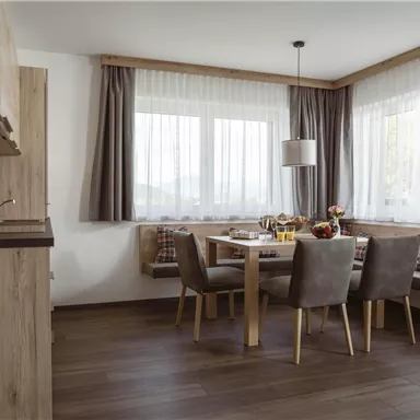 A beautiful dining area with a wooden table and comfortable chairs. Large windows allow for plenty of light and create an inviting atmosphere.
