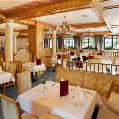 Ein elegantes Restaurant mit schön gedeckten Tischen und modernen Holzdetails. Die Atmosphäre ist gemütlich und einladend.