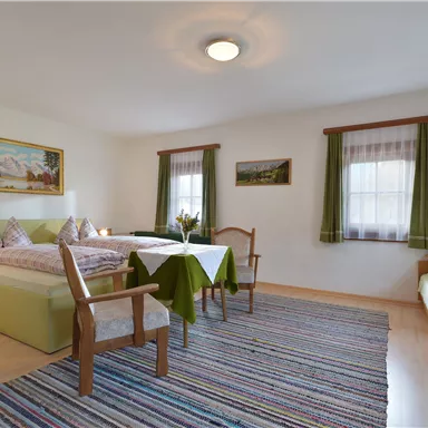 A cozy room with two beds and a table.
Large windows let in plenty of light, and the play of colors creates an inviting atmosphere.
