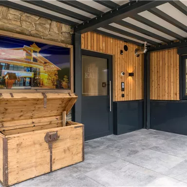 An inviting entrance area with a wooden box and a large picture on the wall. The walls are made of wood and stone, creating a cozy atmosphere.