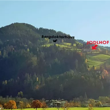 A beautiful mountain with green grass and colorful treetops. Markings indicate the locations of Bergdokt Haus, MÖDLHOF, and Gondelbahn Söll.