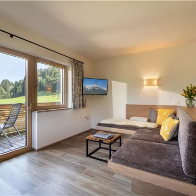 A cozy apartment with a modern living area. Large windows offer a beautiful view of the landscape.