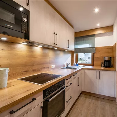 A modern kitchen with wood paneling and elegant appliances. The atmosphere is bright and inviting.