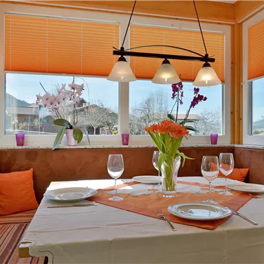 An inviting dining area with a table set for a special dinner. Large windows offer a beautiful view and let in plenty of light.
