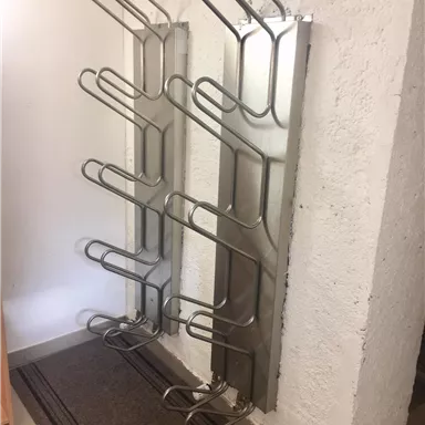 Eisen Kleiderständer an der Wand mit mehreren Haken. Sie sind in einem hellen Raum platziert.