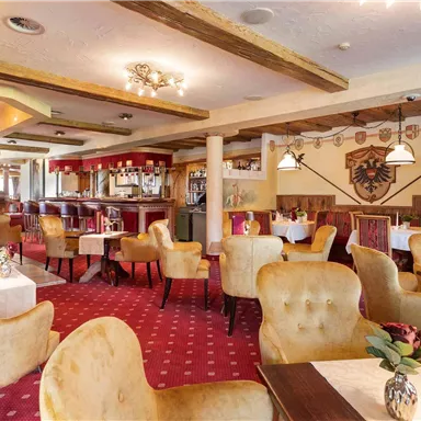 Eine gemütliche Restaurant-Atmosphäre mit bequemen Sesseln und einem eleganten Dekor. Der Raum ist hell erleuchtet und freundlich gestaltet.