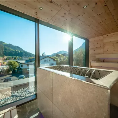 A stylish spa with large windows and a view of the mountains. Lots of wood and a modern design create a relaxing atmosphere.