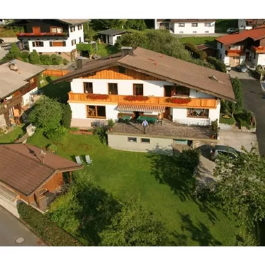 A beautiful house with a balcony and garden in a quiet residential area. Surrounded by other houses and a lot of greenery.