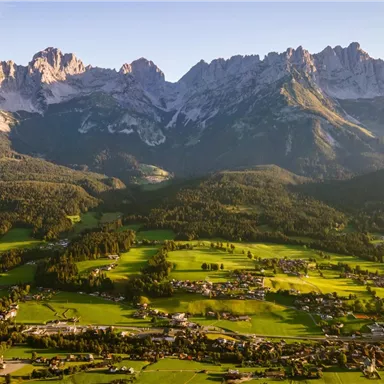 An impressive mountain landscape with majestic peaks and green meadows in the foreground. The image showcases the beauty of nature in all its glory.