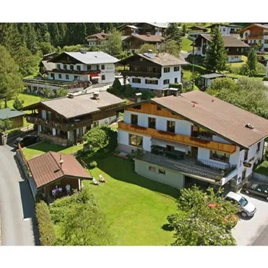 A picturesque alpine landscape with traditional chalets and lush greenery. The surroundings are peaceful and inviting, perfect for a relaxing holiday.