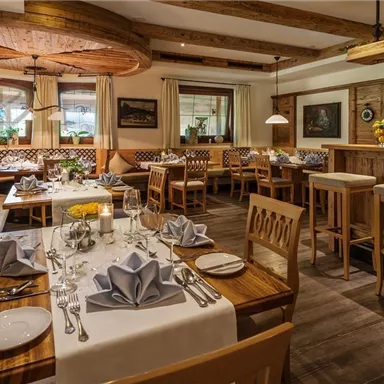 Ein gemütliches Restaurant mit Holzinterieur und sanfter Beleuchtung. Die Tische sind elegant gedeckt und bieten Platz für diners.