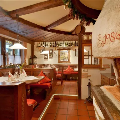 Ein gemütliches Restaurant mit einem rustikalen Kamin und Holzmöbeln. Die Atmosphäre ist einladend und warm.