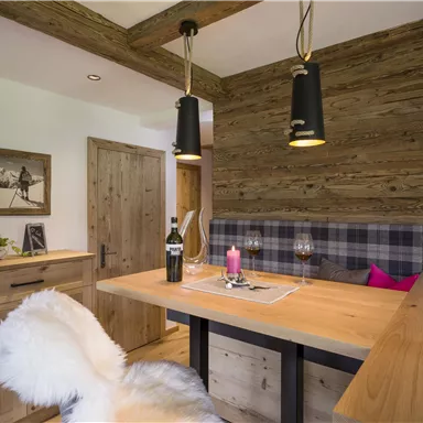 Ein gemütlicher Essbereich mit Holzdekor und einer warmen Atmosphäre. Der Tisch ist elegant gedeckt und die Beleuchtung sorgt für eine angenehme Stimmung.