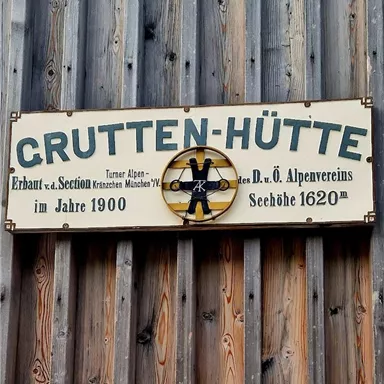 Ein Schild mit der Aufschrift "GRUTTEN-HÜTTE". Es informiert über die Errichtung im Jahr 1900 und die Höhe von 1620 m.
