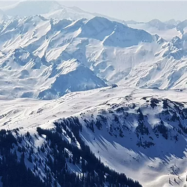 Eine beeindruckende Winterlandschaft mit schneebedeckten Bergen und klaren Himmel. Die majestätischen Gipfel ragen hoch in die Ferne.