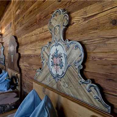 A cozy room with wood paneling and decorative headboards. The decor exudes a warm and inviting atmosphere.