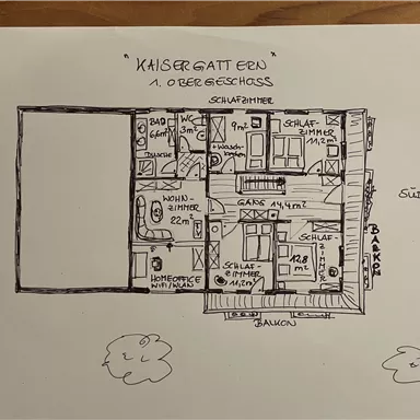 Ein Grundriss des ersten Obergeschosses mit verschiedenen Räumen. Der Plan zeigt Schlafräume, ein Wohn-Esszimmer und Balkone.