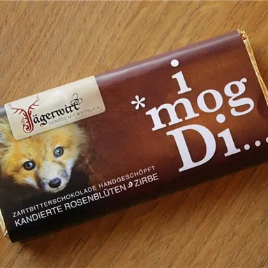 A chocolate bar with the inscription "i mog Di..." and an image of a fox. The packaging features an elegant design in shades of brown and gold.