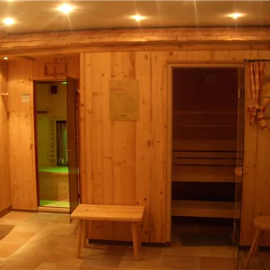 A cozy wellness area with wooden paneling. The sauna is dimmed and offers a relaxing space for recovery.