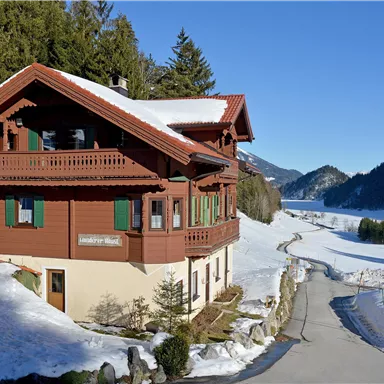 A charming wooden house in a snowy landscape.  
Surrounded by mountains and a picturesque winter scenery.