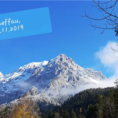 An impressive mountain landscape with snow-covered peaks and clear blue sky. The photo was taken in Scheffau on 10.11.2019.