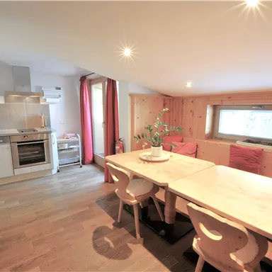 A modern kitchen with a large dining area. Bright colors and cozy furniture create an inviting atmosphere.