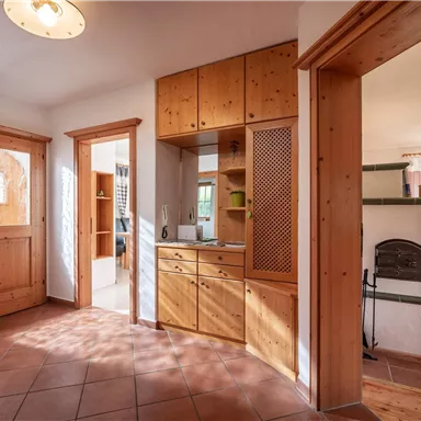 An inviting entrance area with bright wooden cabinets and a beautiful tiled floor. The large window provides plenty of daylight and a friendly atmosphere.