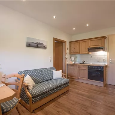 A cozy apartment with a small kitchenette and a dining area. The space is bright and furnished in a modern style, perfect for relaxed moments.