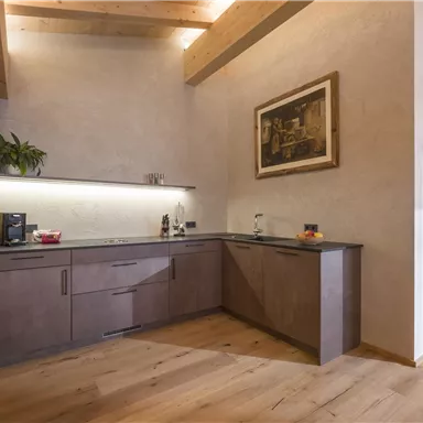 Eine moderne Küche mit Holzregalen und einem großen Fenster. Der Raum hat einen warmen, einladenden Charakter.