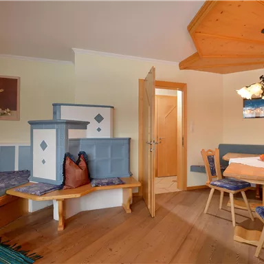 A cozy room with modern wooden decor. There is a sitting area and a dining table, perfect for relaxed evenings.
