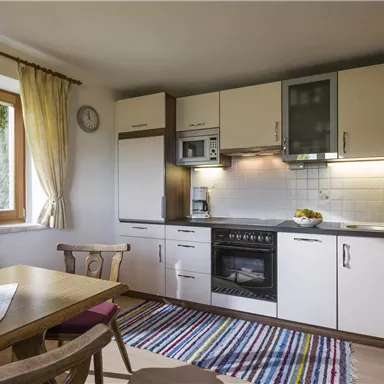 An inviting kitchen with modern appliances and a cozy dining area. Bright windows provide pleasant light and a friendly atmosphere.