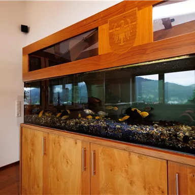 Large aquarium integrated into the custom-made wooden furniture in the living area.