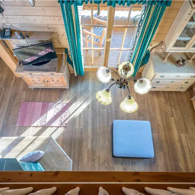 A cozy wooden room with large windows and plenty of natural light. A tranquil space with a modern furniture style and clean lines.