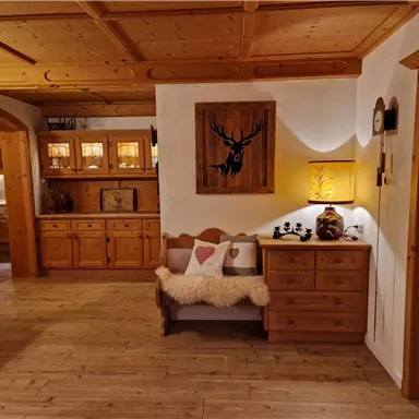 A cozy room with wooden shelves and a bench. On the wall hangs a decorative picture of a deer.
