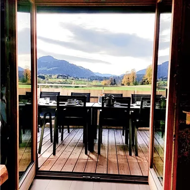 Die Terrassentische sind bereit für Gäste mit einer Aussicht auf die Berge