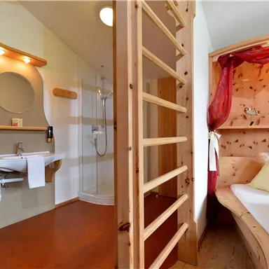 Ein modernes Zimmer mit einem bequemen Bett und einem hellen Badezimmer. Die Einrichtung besteht aus Holz und bietet eine gemütliche Atmosphäre.